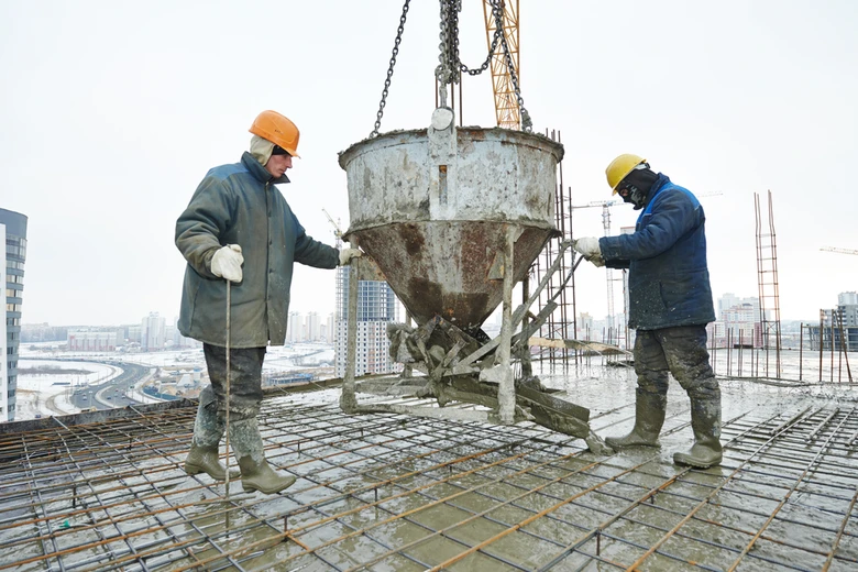 Dělníci nalévají beton na staveništi