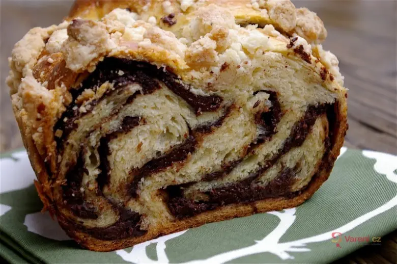 Čokoládová babka s vrstveným náplní na zeleném ubrousku.