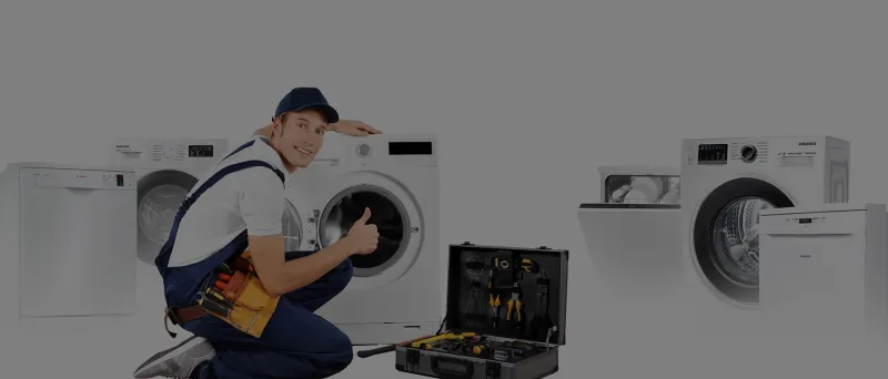 Technik opravující pračku s nářadím kolem sebe.