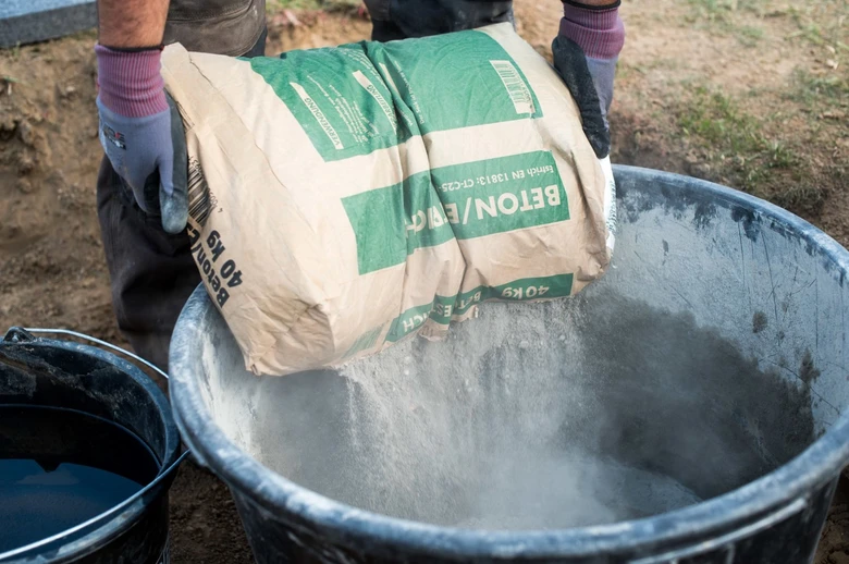 Lidé připravují beton z cementu a vody