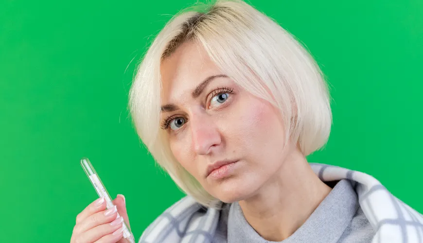 Žena s teploměrem, má zvýšenou teplotu