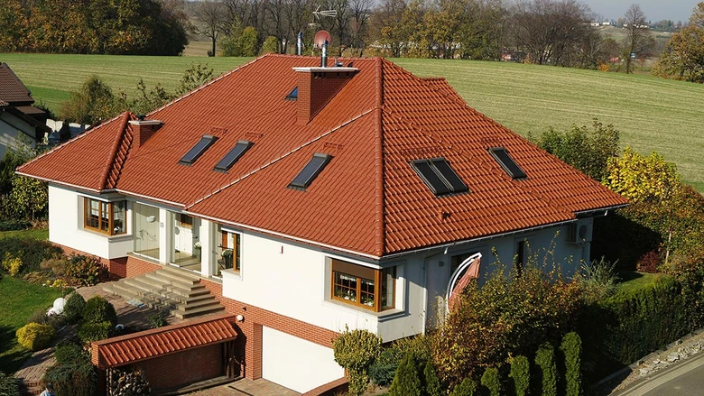 Polovalbová střecha na domě s výhledem do krajiny