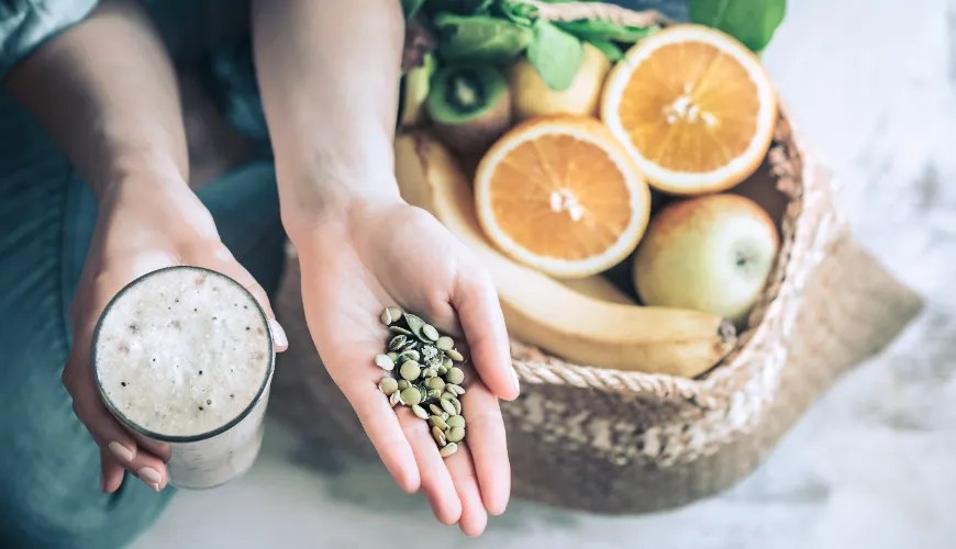 Ruky drží detox koktejl a semínka