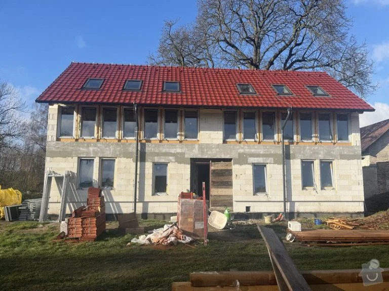 Dům v průběhu stavby s červenou střechou