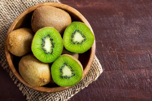 Kořenové plody kiwi v dřevěné miskě
