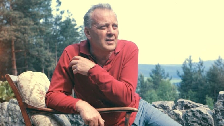 Karel Höger sedí venku na židli v přírodě