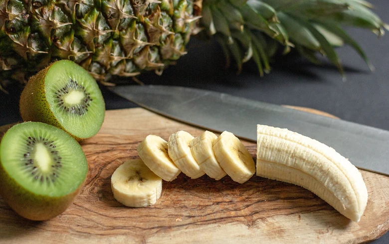 Banán, kiwi a ananas na dřevěné desce
