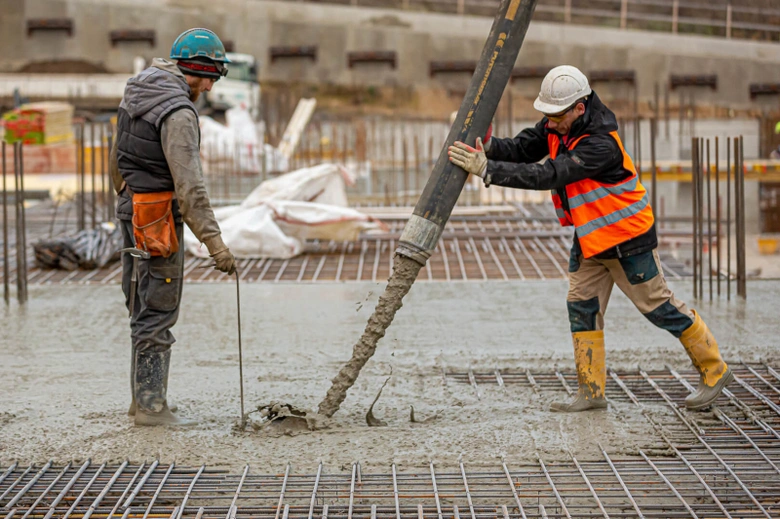 Dělníci nalévají beton na ocelovou armaturu