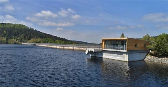 Přehrada Fláje s moderní budovou na vodě.