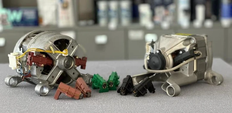 Rozložené díly pračky pro opravu - motor, čerpadlo a konektory.
