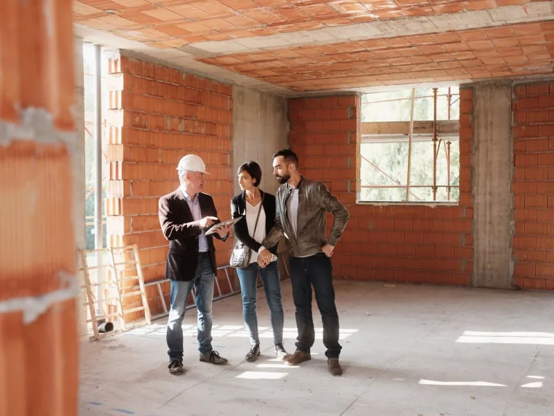 Architekt a klienti prohledávají stavbu domu