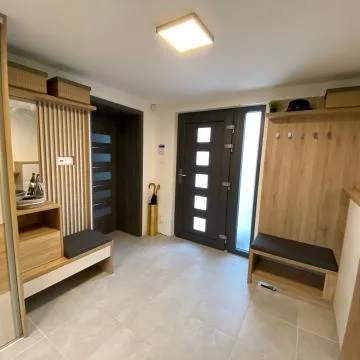Modern vstupní chodba s dřevěnými skříněmi a sedátkem