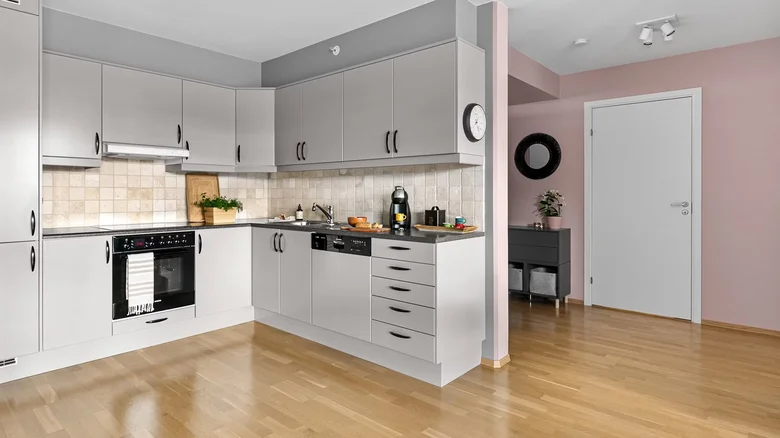Modern kuchyň s šedými skříněmi a dřevěnou podlahou
