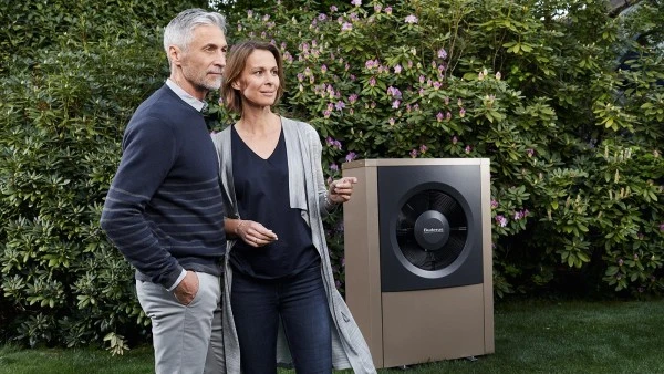 Pára stojí vedle tepelného čerpadla v zahradě