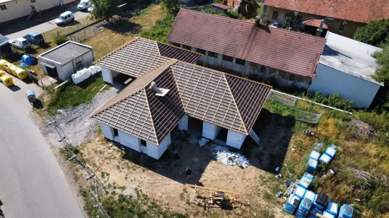 Stavba střechy s viditelným trámovím a materiály.