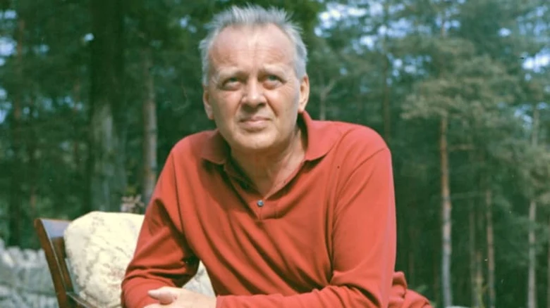 Karel Höger sedí venku v lese