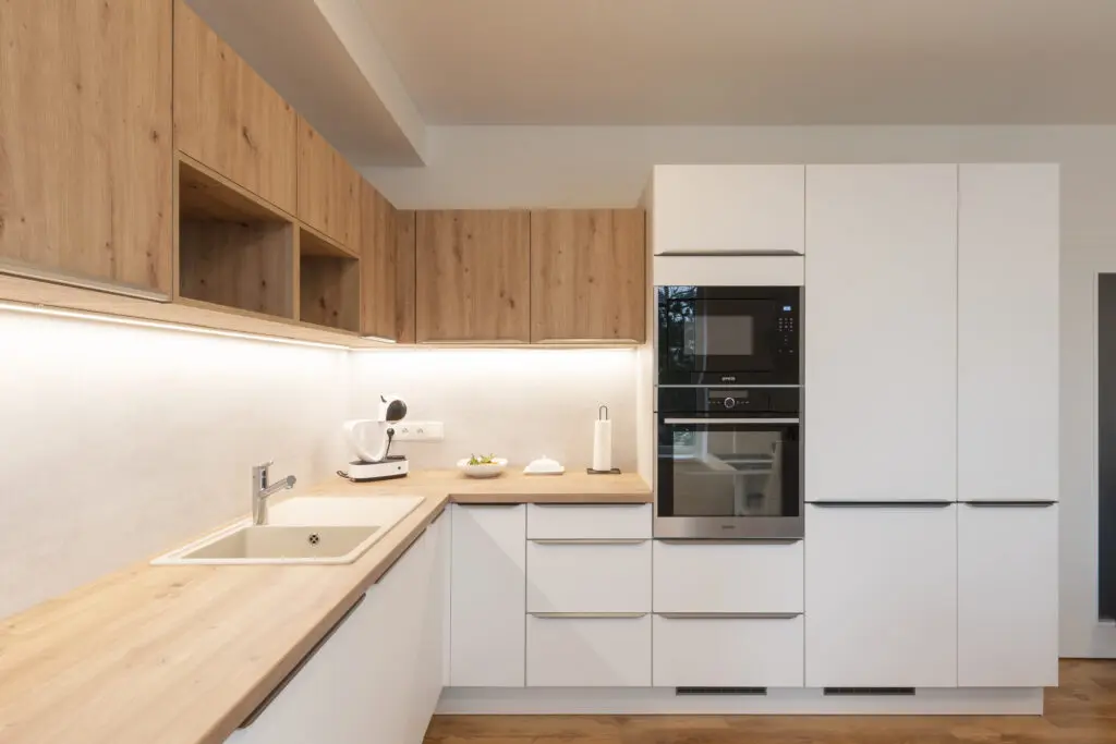 Bílá kuchyně s dřevěnou deskou, moderní design