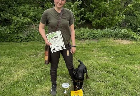 Žena s německým loveckým teriérem a certifikátem