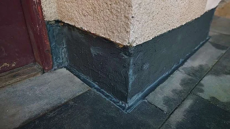 Správně provedený sokl domu s tmavou hydroizolací.