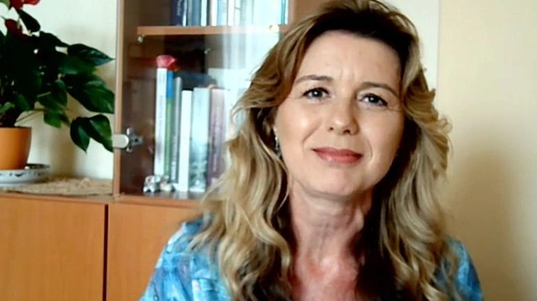 Žena s blond vlasy sedí u knihovny pro článek o pesimismu.