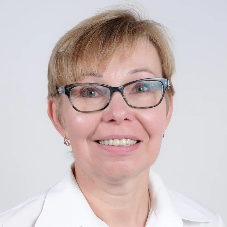 Žena v bílé košili s brýlemi jako lékařka nebo specialista.