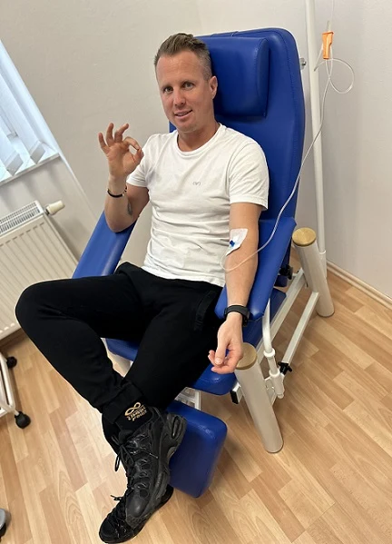 Muž sedí v křesle s nasazenou kontinuální infuzí.