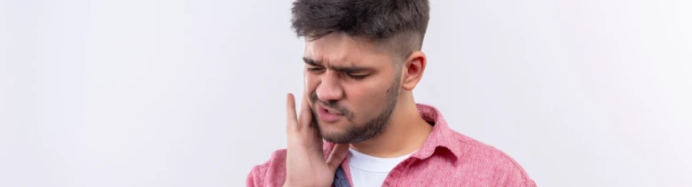 Muž drží ruku na tváři kvůli bolesti slinné žlázy.