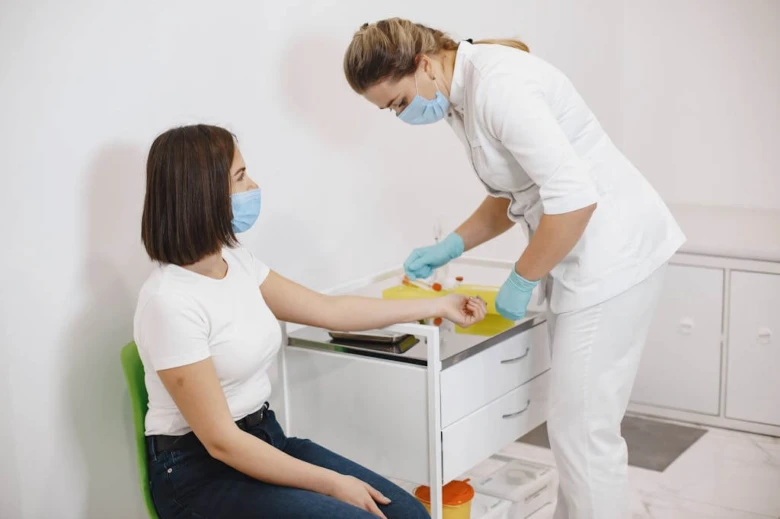 Sestra odebírá krevní vzorek pacientovi pro laboratorní vyšetření.