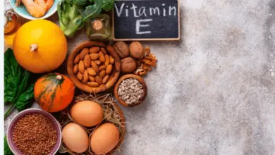 Různé potraviny bohaté na vitamín E jako ořechy, vejce a brokolice.