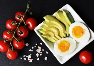 Bílá miska s avokádem, vejcem a rajčaty pro pescetariánství.