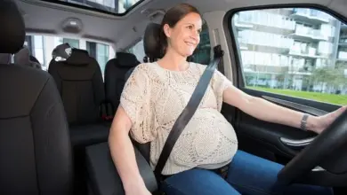 Těhotná žena řídí auto s bezpečnostním pásem přes břicho.