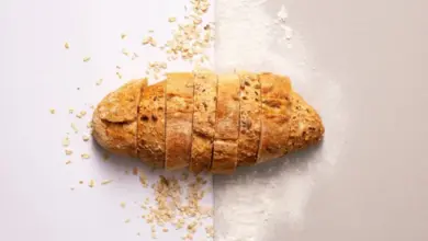 Zlatohnědá nakrájená chlebová houska na bílém pozadí.