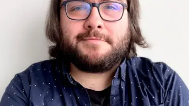 Muž s brýlemi a vousy na bílém pozadí.