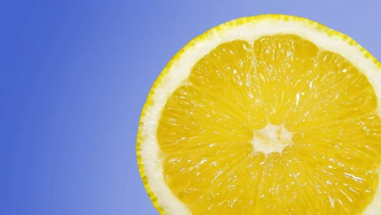 Čerstvý poloviční citron na modrém pozadí.