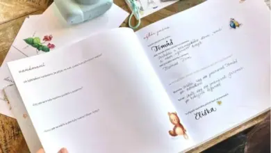 Otevřená kniha s českými jmény pro dítě vedle fotoaparátu.
