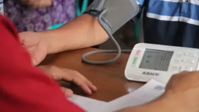 Měření krevního tlaku pomocí digitálního přístroje na paži pacienta.