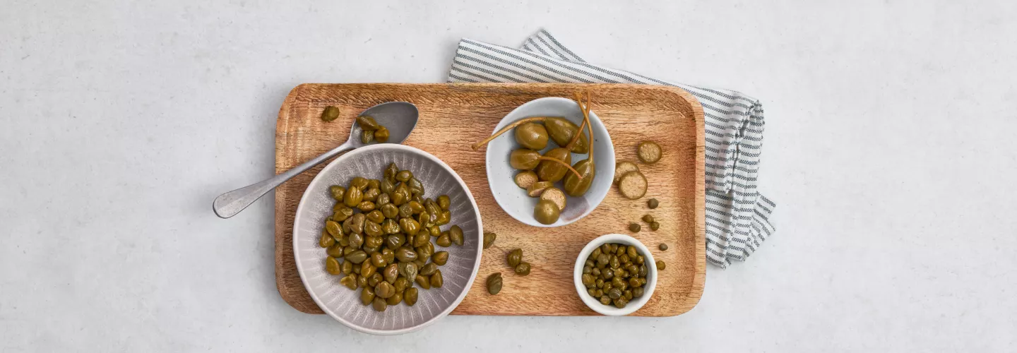 Capers in bowls and on tray