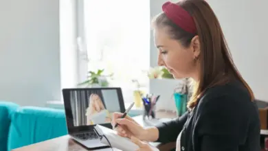 Žena píše poznámky během online kurzu na notebooku.