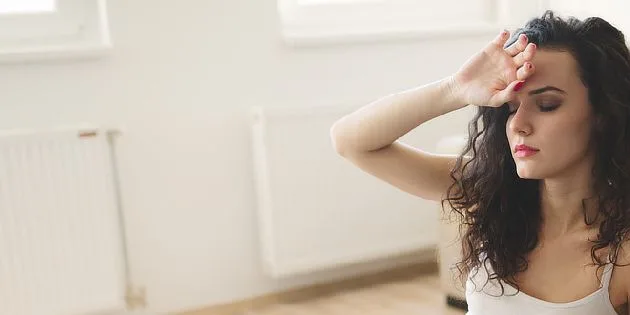 Žena s bolestí hlavy, která může být příznakem opilosti.