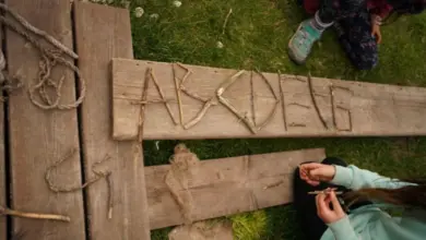 Děti tvoří písmena z přírodních materiálů venku