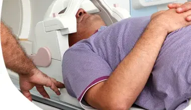 Muž leží v lékařském tomografu při diagnostickém vyšetření.