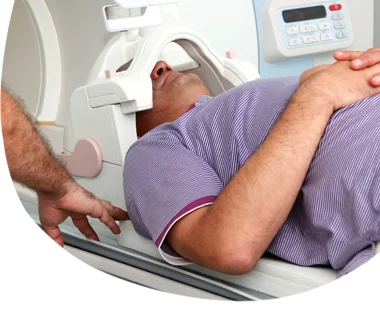 Muž leží v lékařském tomografu při diagnostickém vyšetření.