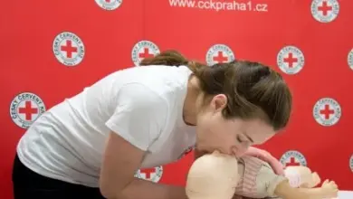 Žena provádí umělé dýchání na miminku při výcviku první pomoci.