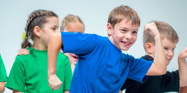 Děti se pohybují a usmívají se při společném cvičení.