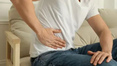 Muž drží ruku na podbřišku kvůli bolesti.