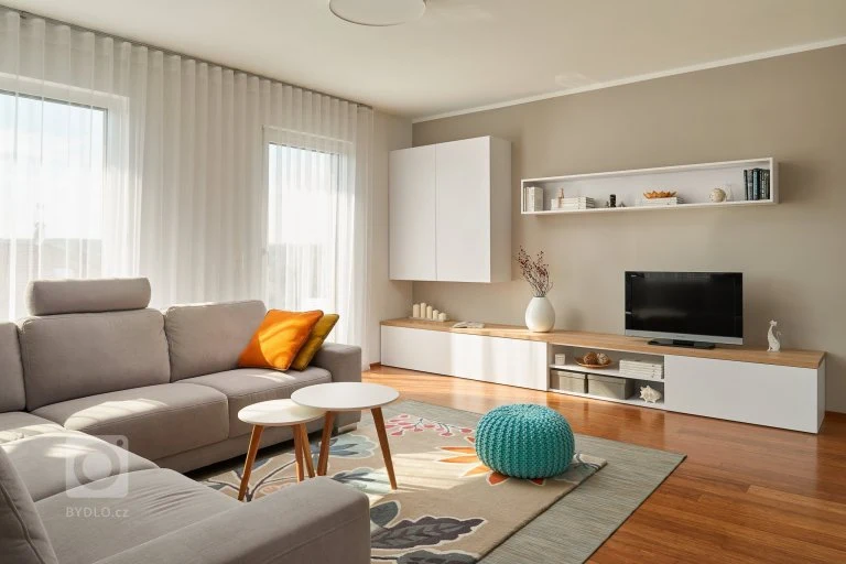 Moderní obývací pokoj s béžovými stěnami a nábytkem.