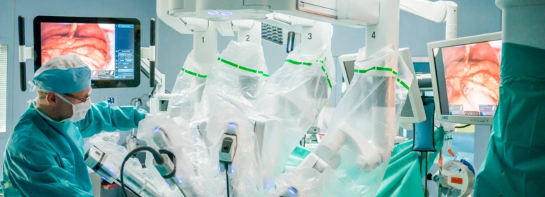 Chirurg operuje robotický systém v operační místnosti.
