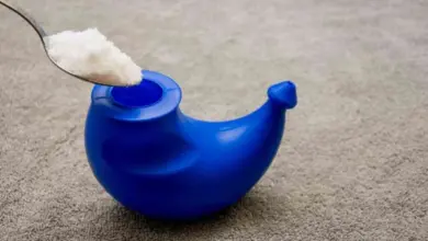 Modrý nosní zavlažovač s lžící soli pro přírodní léčbu rýmy.