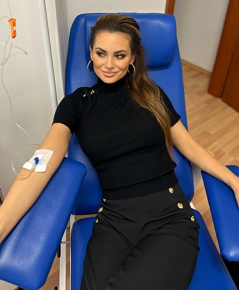 Žena dostává kontinuální infuzi přes žílu v nemocničním křesle.