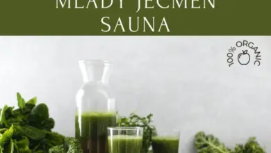 Čerstvá zelená šťáva s listovými zeleninami na dřevěném talíři.